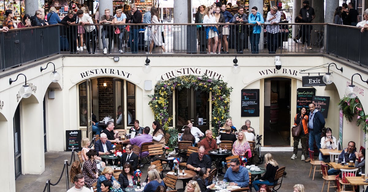 A bustling dining scene at Covent Garden in London with people enjoying meals outdoors.