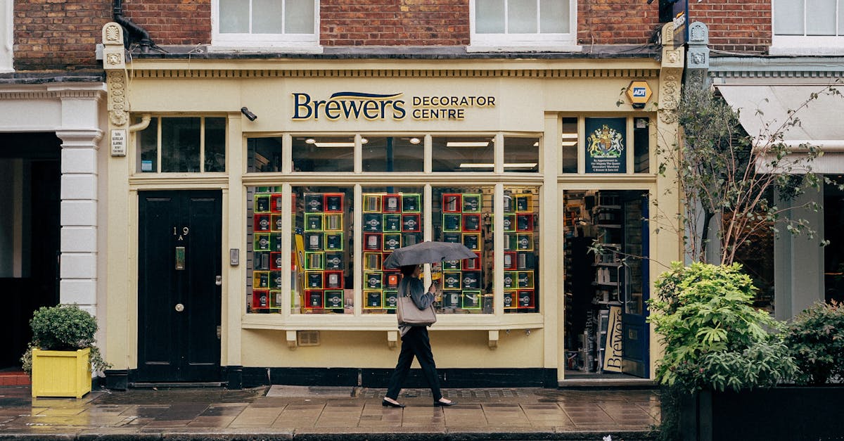 Cashback - Person with umbrella walks past colorful shop in rainy Notting Hill, London.