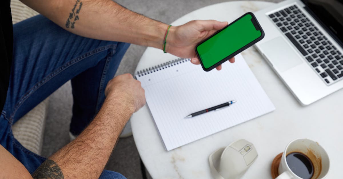Side Hustles in the UK - Top view of a modern workspace with a smartphone, laptop, notebook, and coffee.
