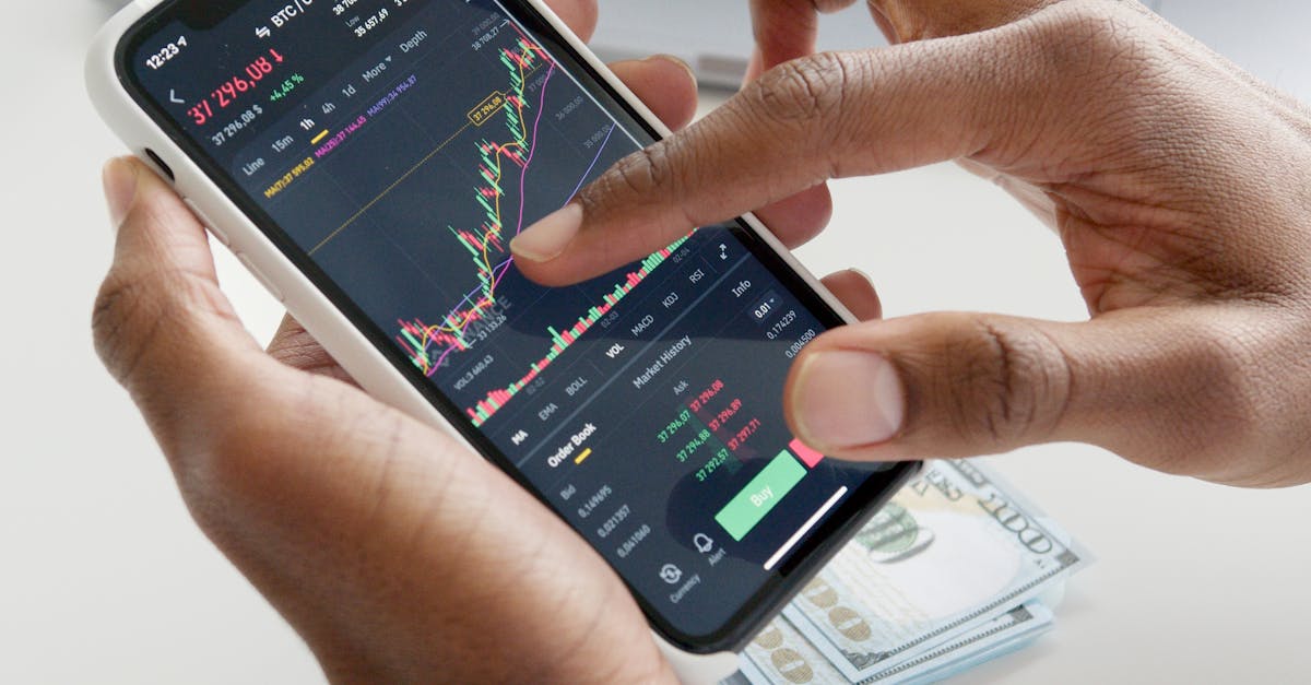 Recurring Expenses Savings - Hands using smartphone trading app with charts, dollar bills in background.