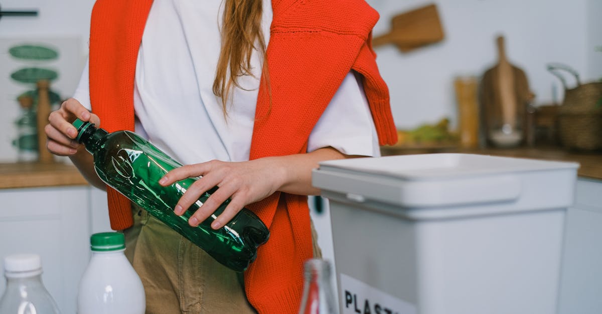 Eco-friendly household items - Woman sorting plastic bottles into a recycling bin, promoting eco-friendly practices at home.