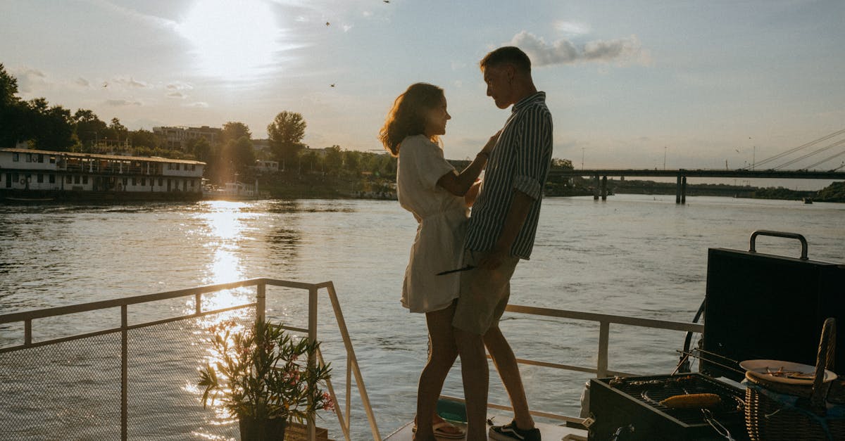 Saving on Luxury Travel - A couple enjoys a romantic moment on a yacht with a stunning sunset over the river, evoking feelings of love and adventure.