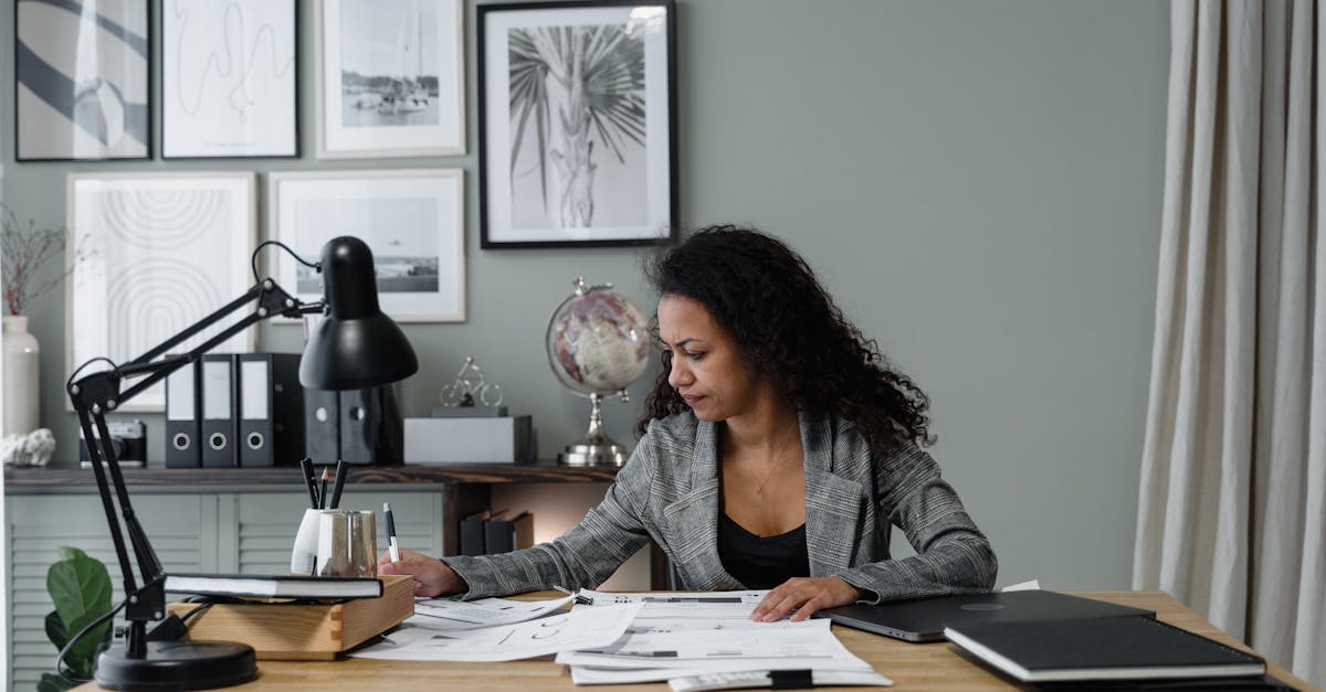 Budgeting Tips for Millennials - Businesswoman evaluates documents at a modern desk in a stylish office setting.