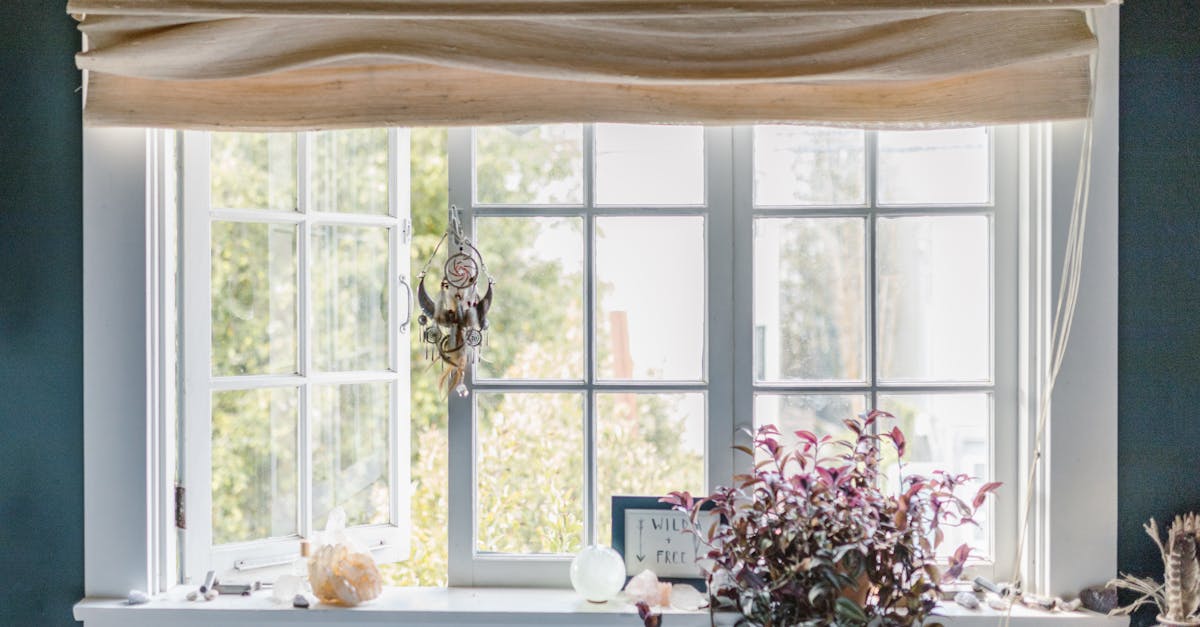 Green energy savings - A serene indoor window scene with a dreamcatcher, crystals, and potted plant.