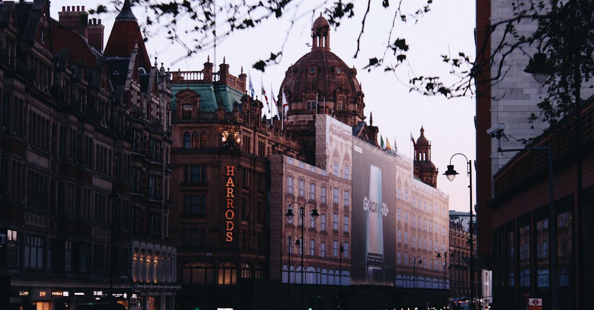 Maximising profit online store - Dusk view of the historic Harrods building in London with busy city traffic.