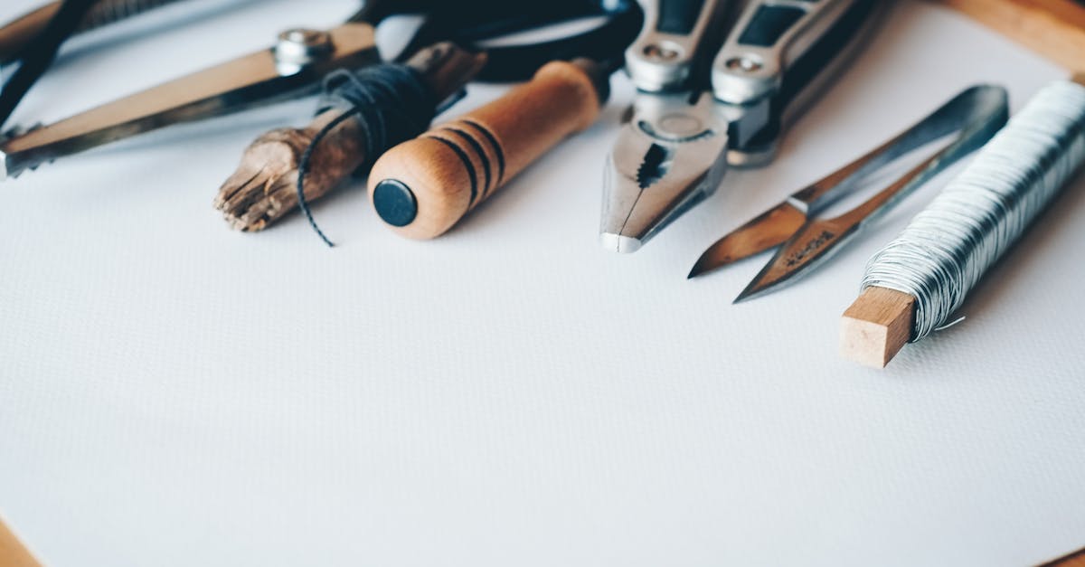 repurpose unwanted items - A selection of artisan tools and handmade crafts displayed on a white desk, perfect for creative projects.