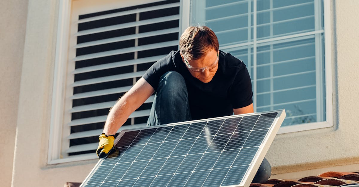 Eco-friendly savings - A worker installing a solar panel on a residential rooftop under bright sunlight.