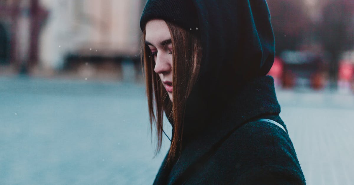 Smartphone money making - A woman in winter attire using a smartphone on a city street.