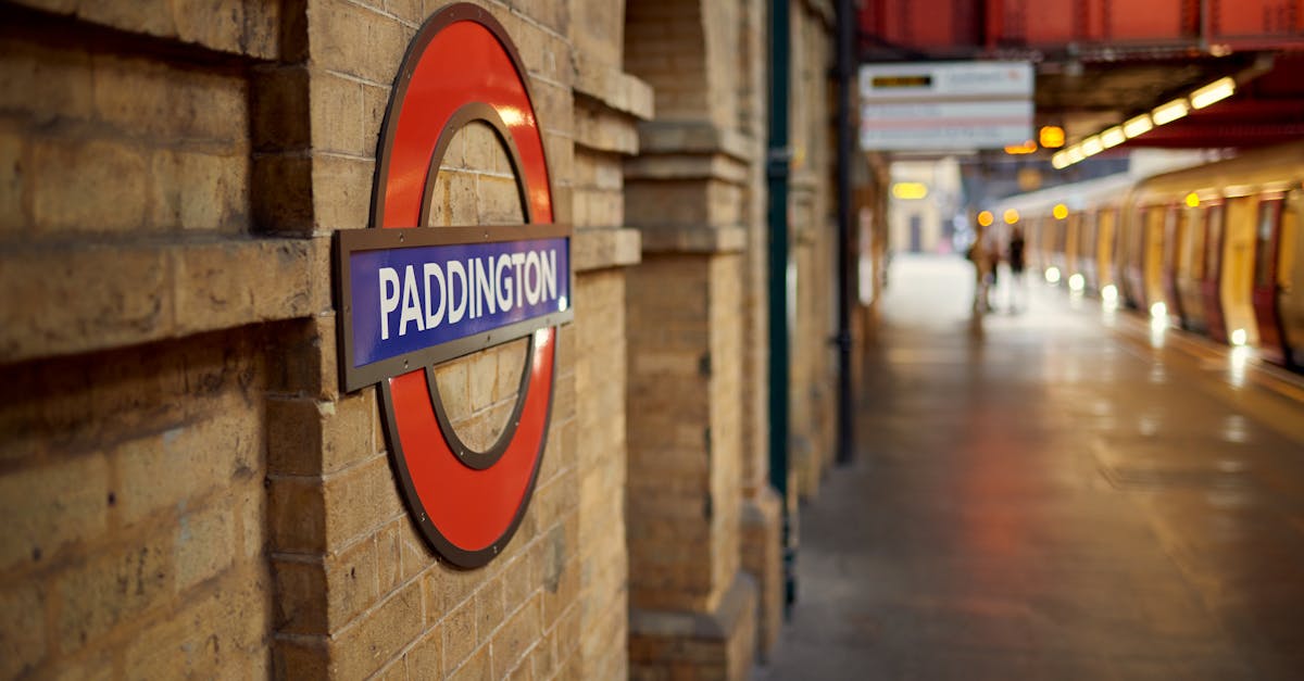 Saving money on UK public transportation - View of Paddington Station in London with classic roundel and train on platform.