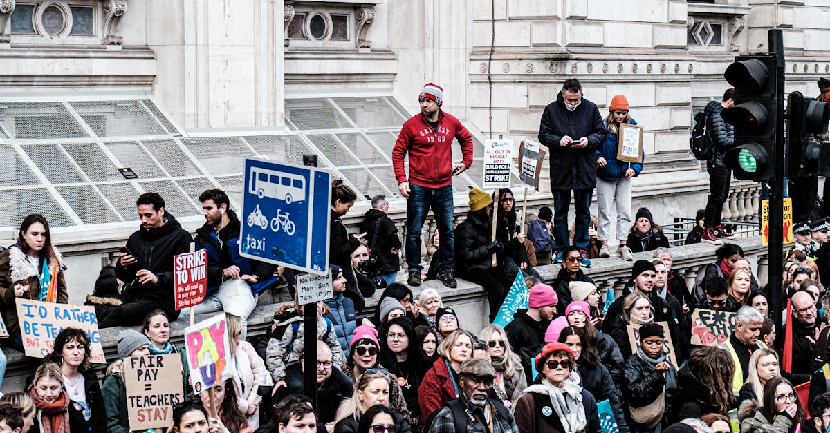 Online Surveys Income UK - Crowd of diverse protesters in an urban setting, showcasing vibrant signs and banners.