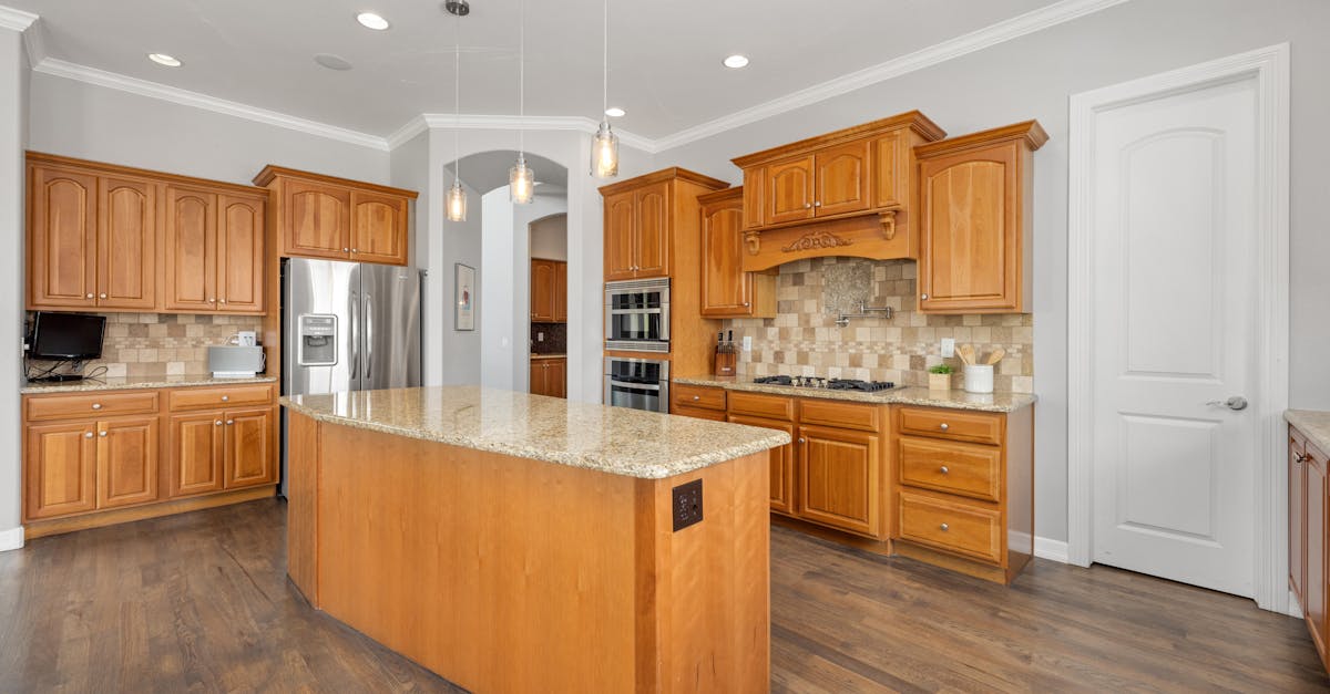 Food Budget Savings - Bright kitchen featuring a granite island and wooden cabinetry, ideal for contemporary homes.