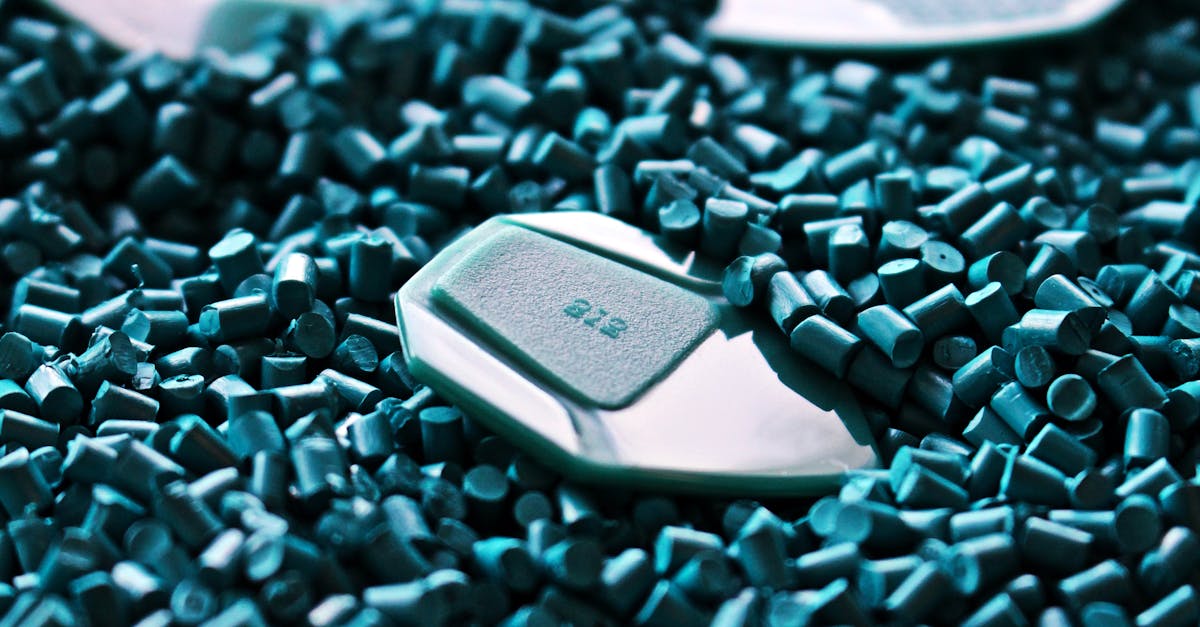 Recycled Material Manufacturing - Detailed view of green guitar picks surrounded by textured plastic pellets.