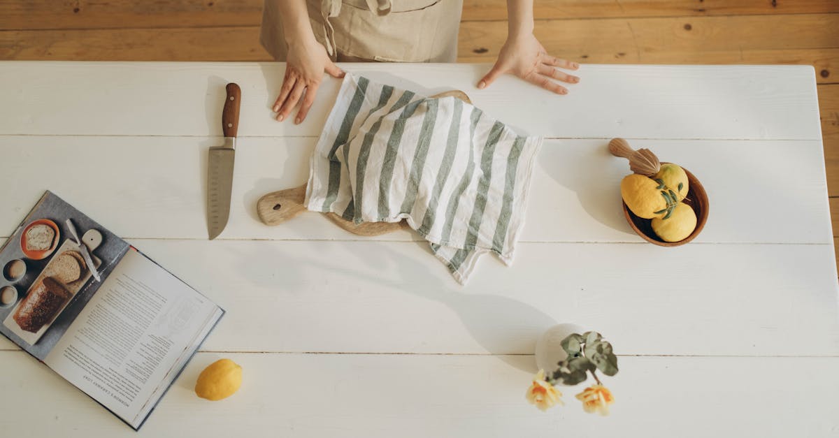 Meal Prep Savings - Overhead view of a woman in a kitchen preparing a meal with lemons and cookbook.