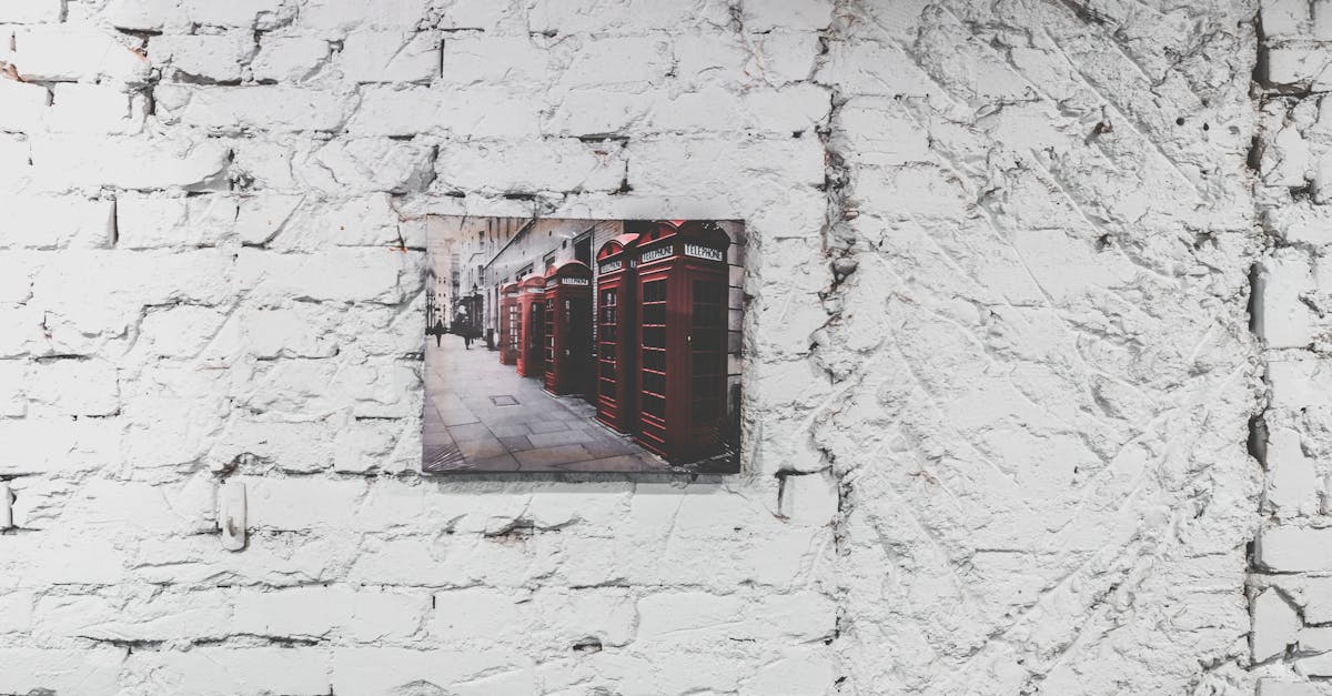 urban farming - A canvas of iconic red phone booths displayed on a textured white brick wall.