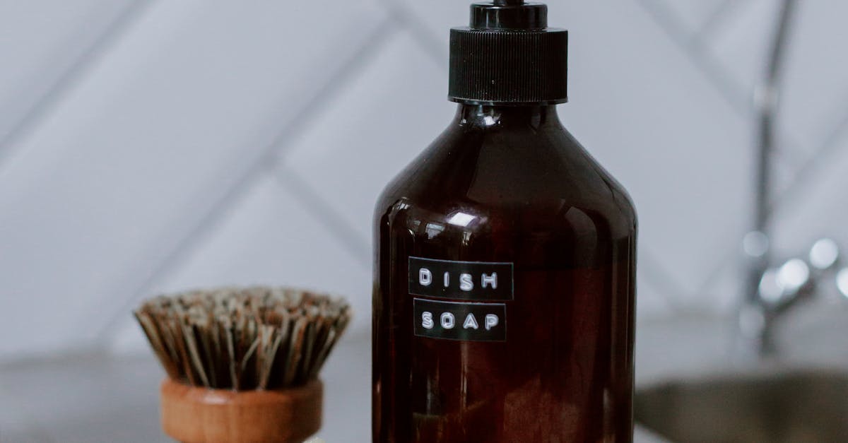 eco-friendly cleaning - A stylish arrangement of eco-friendly kitchen cleaning products on a countertop with a chevron tile backsplash.