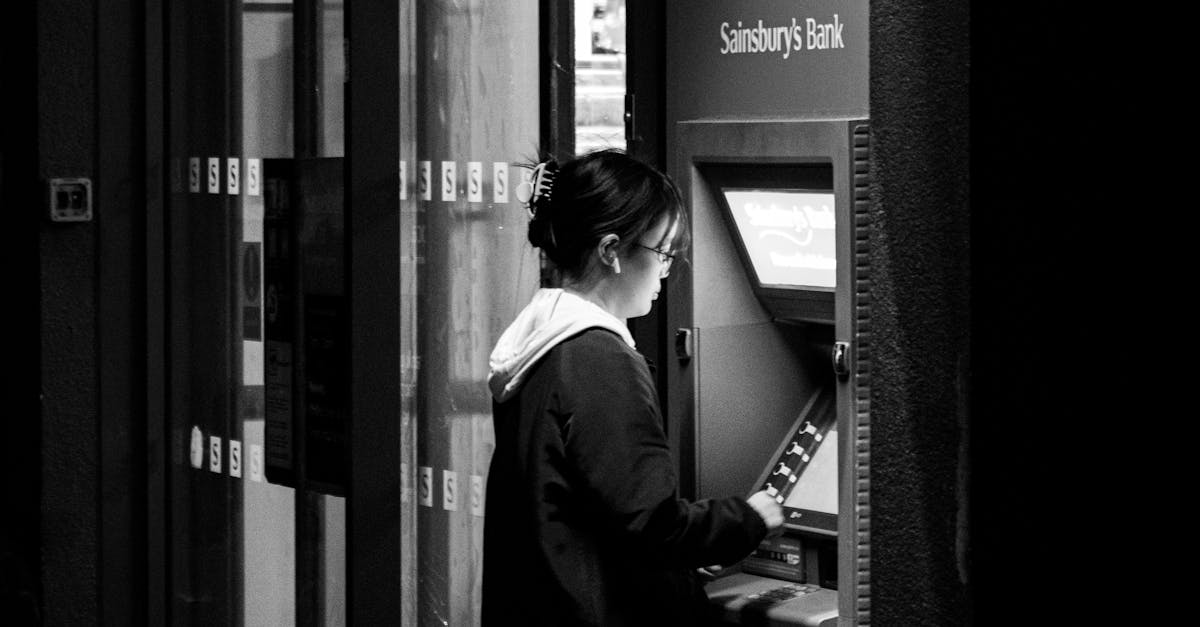 Cancel Unused Subscriptions - A woman withdraws cash from an ATM outside Sainsbury's in Cambridge.