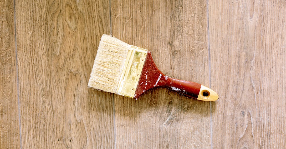 Upcycling in the UK - A used paintbrush lying on a wooden floor, ideal for renovation and DIY themes.