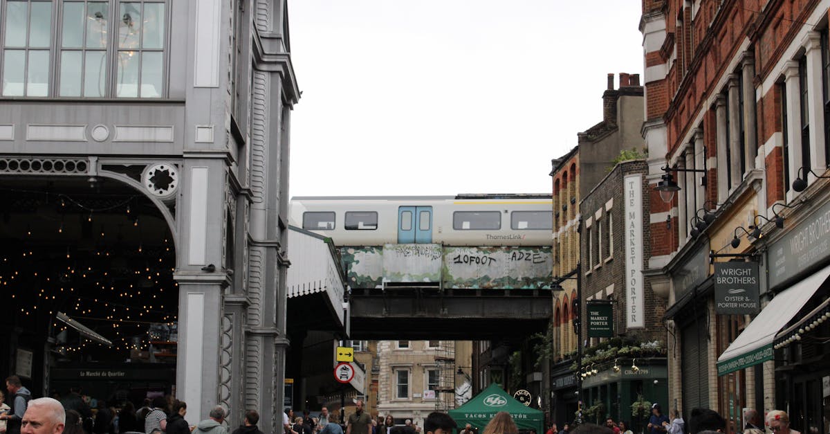 Selling at UK Farmer's Markets - Lively street scene at Borough Market with an overhead train in London.