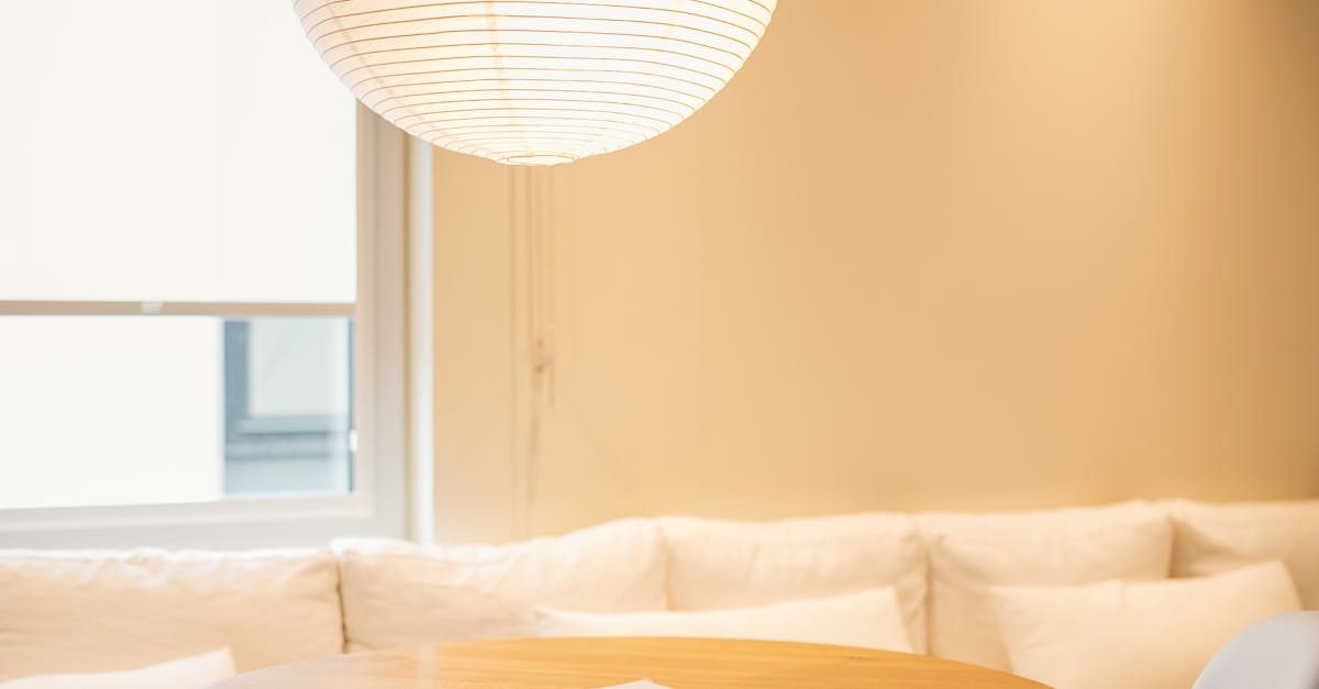 Furniture Restoration - Cozy minimalist interior with a round table, unique chairs, and a paper lantern lighting.