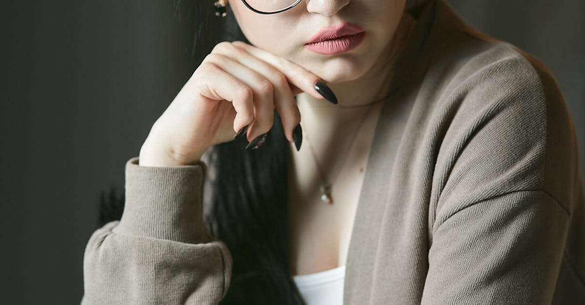 Regular Savings Accounts - Young woman with glasses contemplating financial documents indoors.