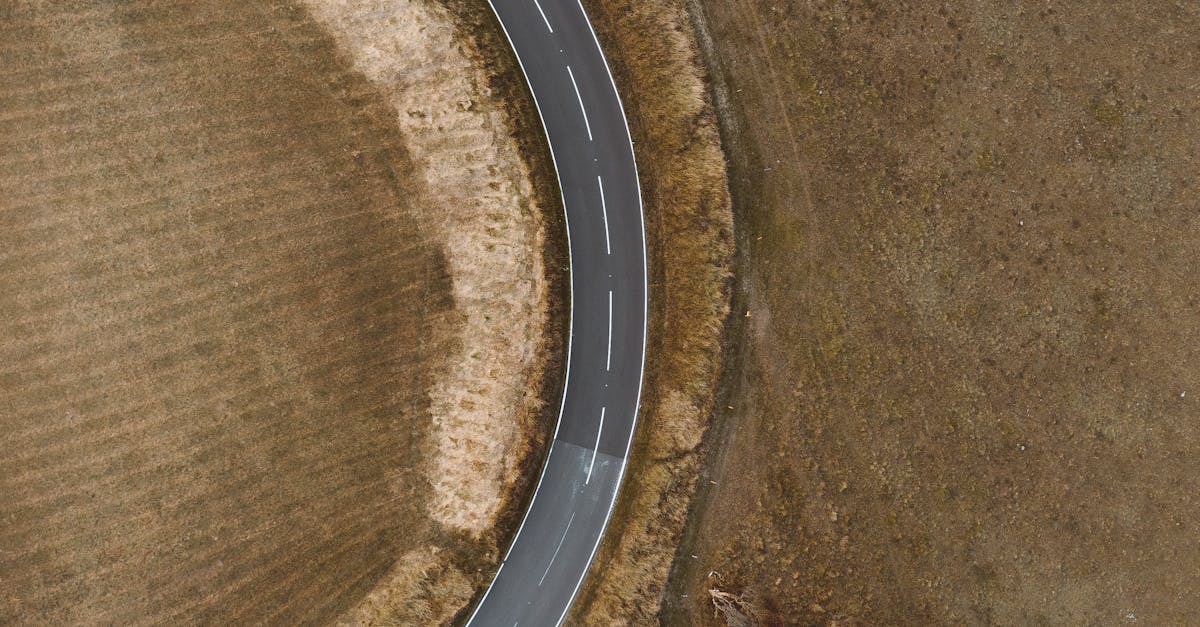 budget road trip UK - Drone shot capturing a curvy road through the English countryside, showcasing rural travel.