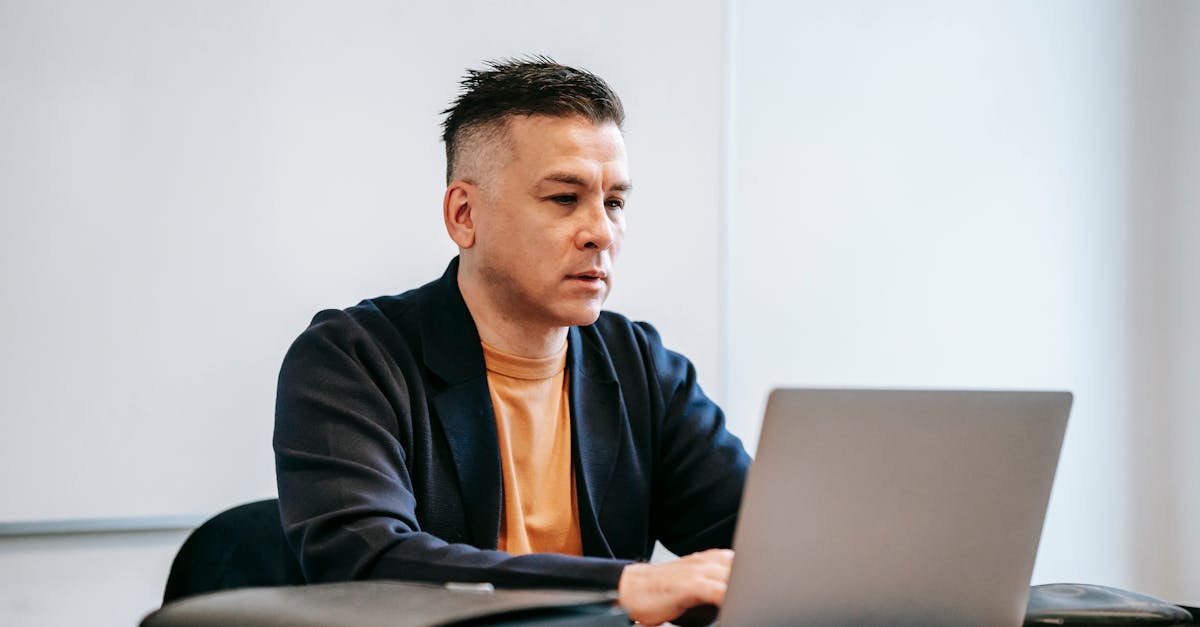 online reselling UK - A concentrated man working remotely on his laptop in a modern indoor office setting.