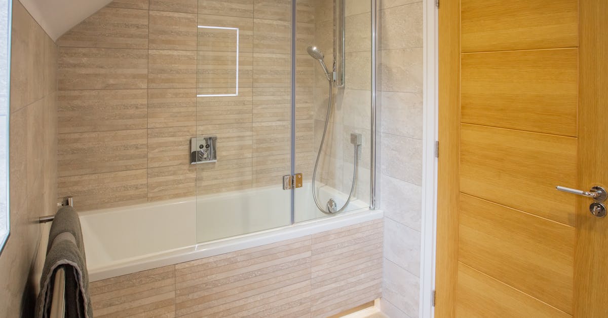 repurpose household items - Bright modern bathroom featuring a glass shower and wooden door in Colchester, UK.
