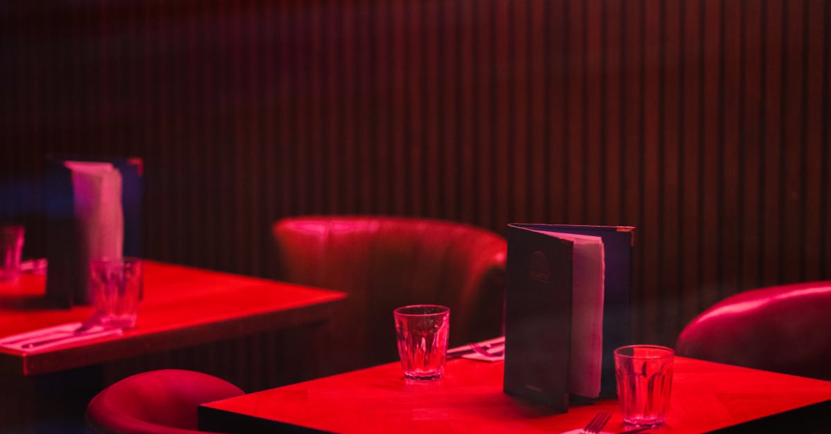 Frugal Fine Dining - Warm interior of a restaurant with red lighting in London, featuring elegant dining tables.