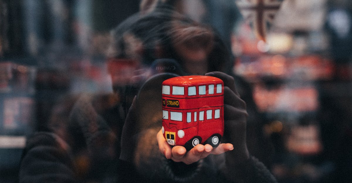 recycling money-saving tips - Reflective close-up of a London double-decker bus toy, captured in a shop window.