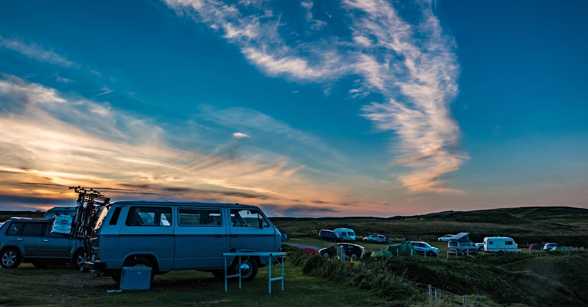 Budget Motorhome Travelling UK - A scenic sunset view of Volkswagen campervans parked in Durness, Scotland.