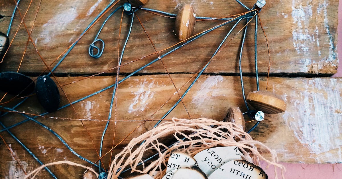 Upcycling DIY Projects - Close-up of a rustic handmade craft made with wire, wooden discs, and paper on a wooden surface.
