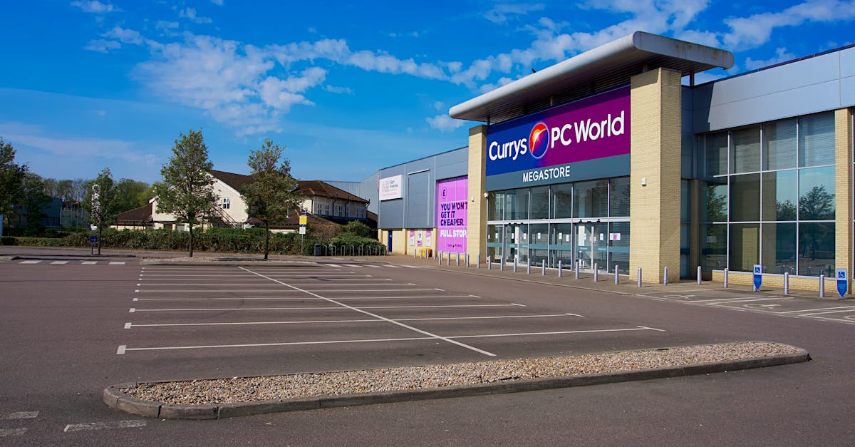 Circular Economy - Empty parking lot outside Currys PC World megastore on a clear day in England.